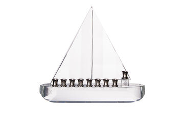 Clear crystal sailboat menorah with two triangular sails and nine silver-tone cups along the hull