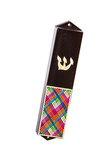 Dark wood mezuzah case with straw Shin above a single long panel of pink, orange, blue and green straw