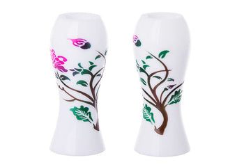 Pair of opaque white hourglass candlesticks painted with a pink blossom, green leaves and a brown branch
