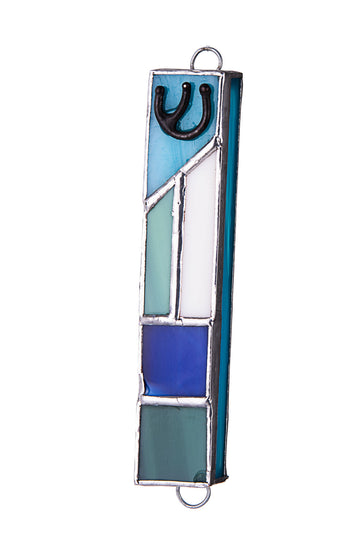 Stained glass mezuzah with angled light blue and white panels over cobalt and sea green squares, black Shin at top