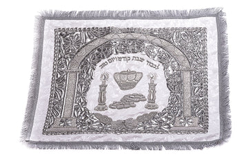 White and silver-tone challah cover with an arch, crown, candlesticks, challah loaves, Hebrew text and fringed edge