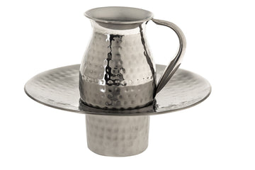 Small hammered stainless steel pitcher seated in a wide-rimmed hammered basin