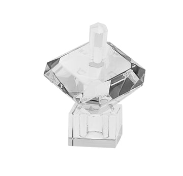 Diamond-cut crystal dreidel with symmetrical facets and short stem on a square clear stand