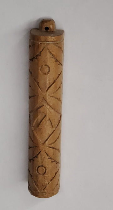 Teak wood mezuzah case with carved crisscross and circle pattern and a small hanging loop at top