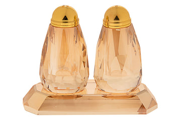 Pair of amber crystal salt and pepper shakers standing on a matching rectangular tray