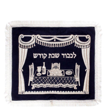Navy velvet challah cover with silver embroidered curtain framing a Shabbos table and Hebrew lettering