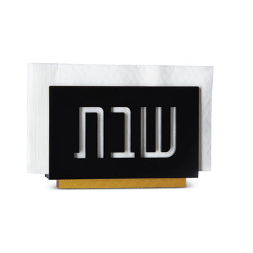Black lucite Shabbos napkin holder filled with white napkins on its gold base