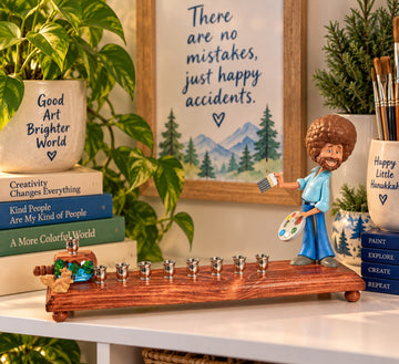 Bob Ross figure on a wood menorah base with painting props