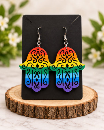 Rainbow filigree hamsa earrings on a black card