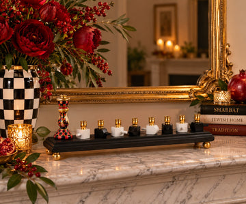Red, black and gold dreidel menorah on a mantel