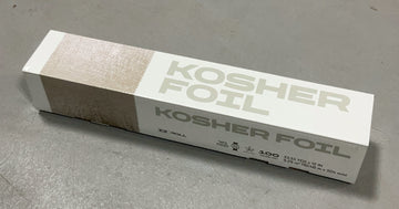 White and beige Kosher Foil aluminum foil box marked EZ Roll and 100, lying on a gray floor