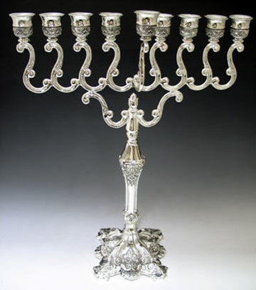 Silver plated menorah with scrolled branches, a decorated stem and an ornate footed base