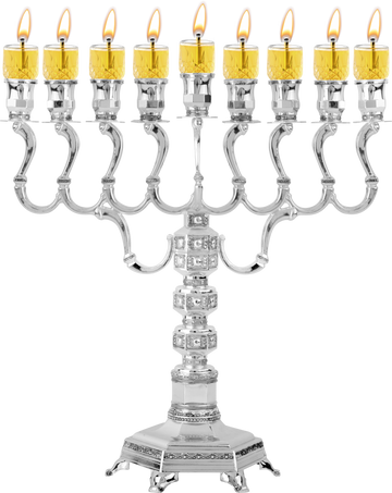 Ornate silver-plated oil menorah with lit glass oil cups on scrolled arms and a decorated pedestal base