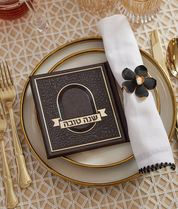 Simchonim Mosaic style Shanah Tovah booklet, shown on a table setting