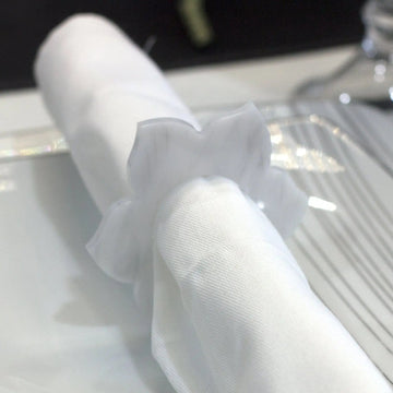 Fabric bow-style napkin ring on a rolled white napkin
