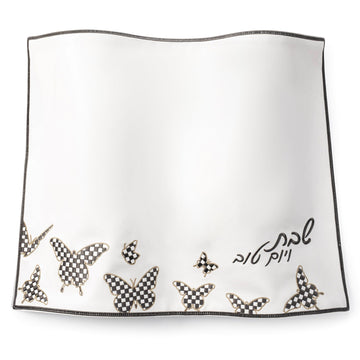 White leather challah cover with checkered butterfly embroidery along the edge