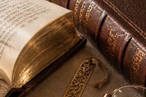 Seforim and books on a wooden shelf