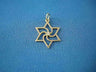 Open gold Star of David pendant with swirling pinwheel center and small diamond, on blue fabric