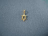 Tiny elongated diamond cut 14K gold Star of David charm with bale on dark blue fabric
