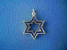 Open gold Star of David with nested outlines filled in dark blue enamel, on blue fabric