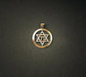 Two-tone gold Star of David with chai centered inside a polished yellow gold ring, shown on a dark grey background