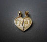 Gold-tone split heart pendant reading Mizpah across a textured face, two bails, on grey