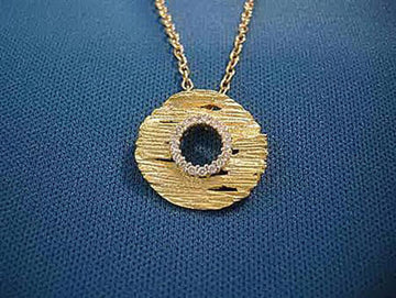 Textured gold disk pendant with an inner ring of small diamonds, on a gold cable chain