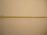 Thin twisted yellow gold rope chain laid horizontally with a ring clasp at left