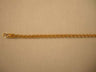 Braided wheat-style gold Spiga chain laid horizontally on beige, ring clasp at left