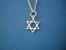 Petite open silver Star of David on a curb chain against blue fabric