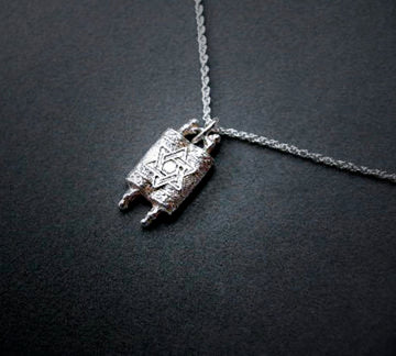 Miniature sterling Torah scroll pendant with Star of David on a rope chain, dark gray backdrop