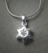 Puffed polished silver Star of David with a small star-cut clear stone in the middle