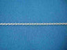 Fine sterling silver Boston link chain laid straight across blue knit fabric