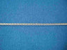 Shimmering sterling silver curb chain with flat links on blue fabric
