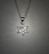 Dainty silver Star of David with clear stones in its points and an open hexagon, on grey