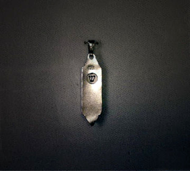 Back of the silver mezuzah charm with a round window showing the letter Shin
