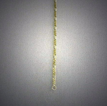 Fine yellow gold Figaro chain with alternating short and long links hanging straight down