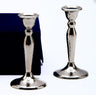 Pair of hammered stainless steel candlesticks beside a blue velvet presentation box