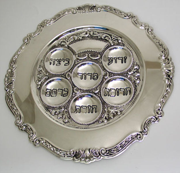 Round silver plated Seder plate with six Hebrew-labeled wells and a scrolled decorative rim