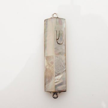 Mother of pearl mezuzah case with silver edging, a silver Shin and loops at each end