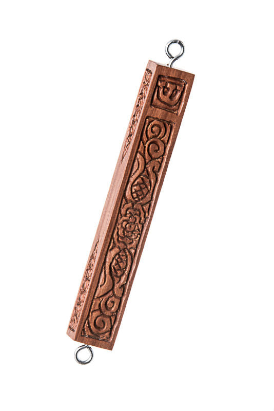 Reddish carved wood mezuzah case with swirl relief, shin at top and metal hanging loops