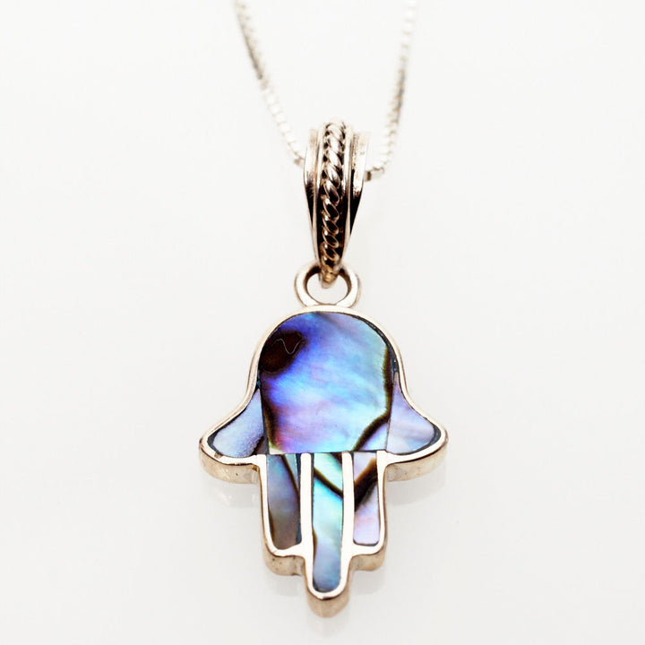 Petite abalone shell hamsa pendant outlined in sterling silver on a box chain