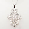 Openwork sterling Hamsa dotted with round CZs on a curb chain, pale background