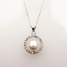 Freshwater button pearl inside a sterling silver ring of sparkling CZs on a fine link chain