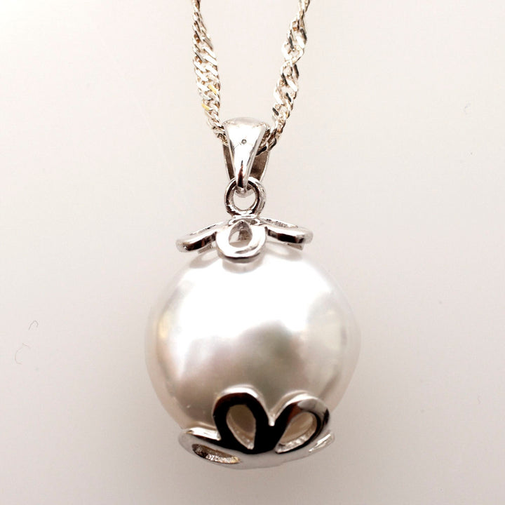 Round white coin pearl with scalloped silver caps like a pomegranate, on a twisted Singapore chain