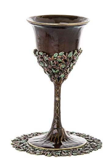 Brown enamel Kiddush cup with jeweled green leaf band and twisted stem on a leaf-edged tray