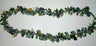 Green, blue and tan gemstone cluster necklace laid in a long oval on white