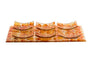 Amber and orange glass Seder plate with six small curved matching dishes set on the tray