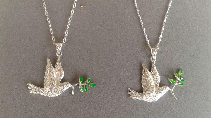 Two sterling silver dove pendants with green enamel olive branches shown on two different chains
