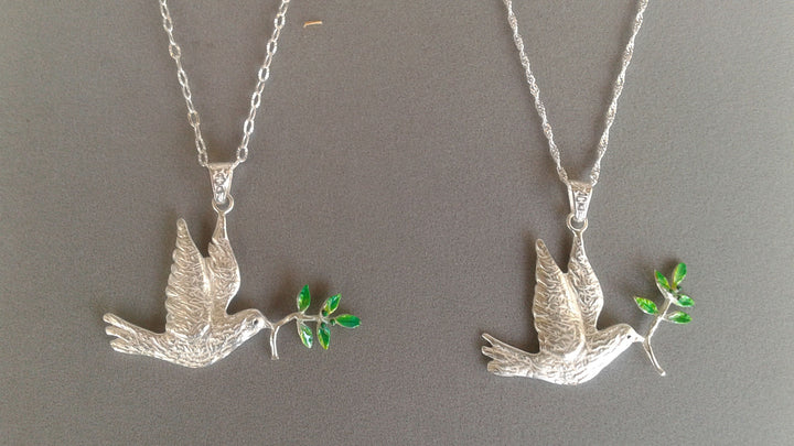 Two sterling silver dove pendants with green enamel olive branches shown on two different chains